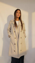 Trench beige long AZEL Paris porté de face, double boutonnage et ceinture